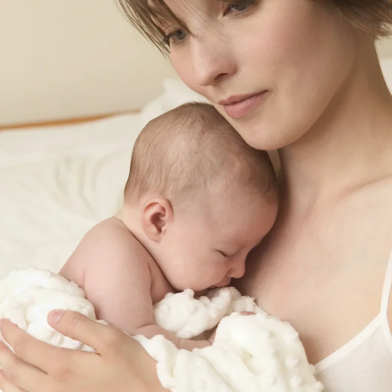 Mother holding her newborn baby — postpartum hair loss